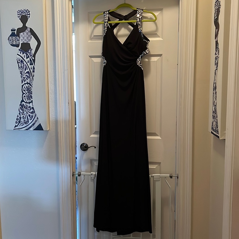 Black gown with back design. Silver sequin detail. Cut out sides